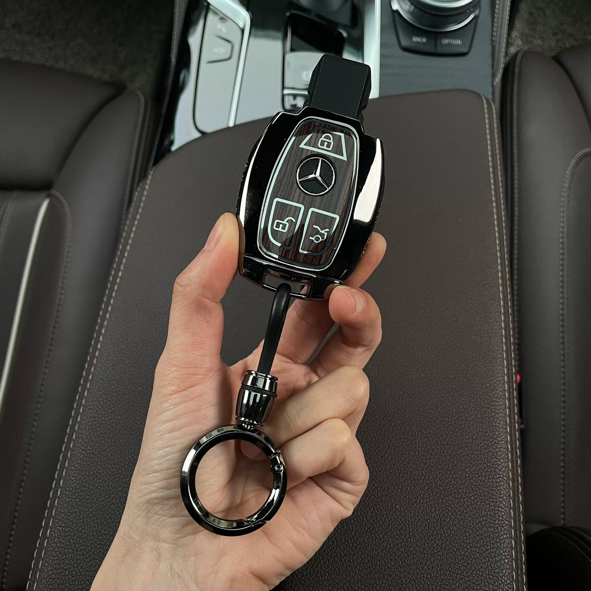 Back of the Mercedes-Benz woodgrain key case showing the button cover and ring keychain