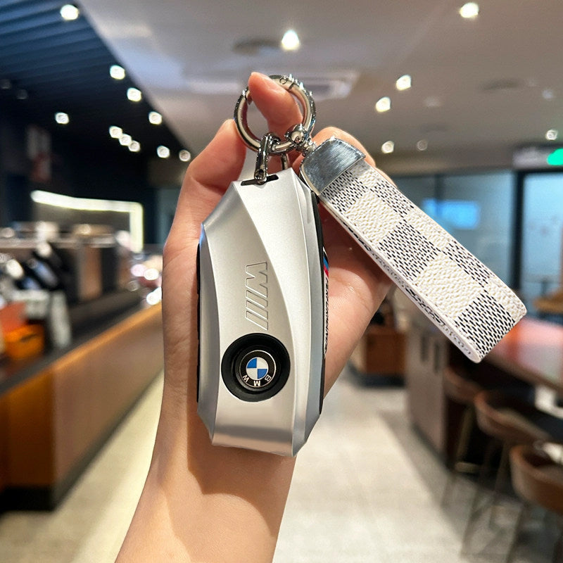 BMW key case silver with white plaid strap keychain held in hand
