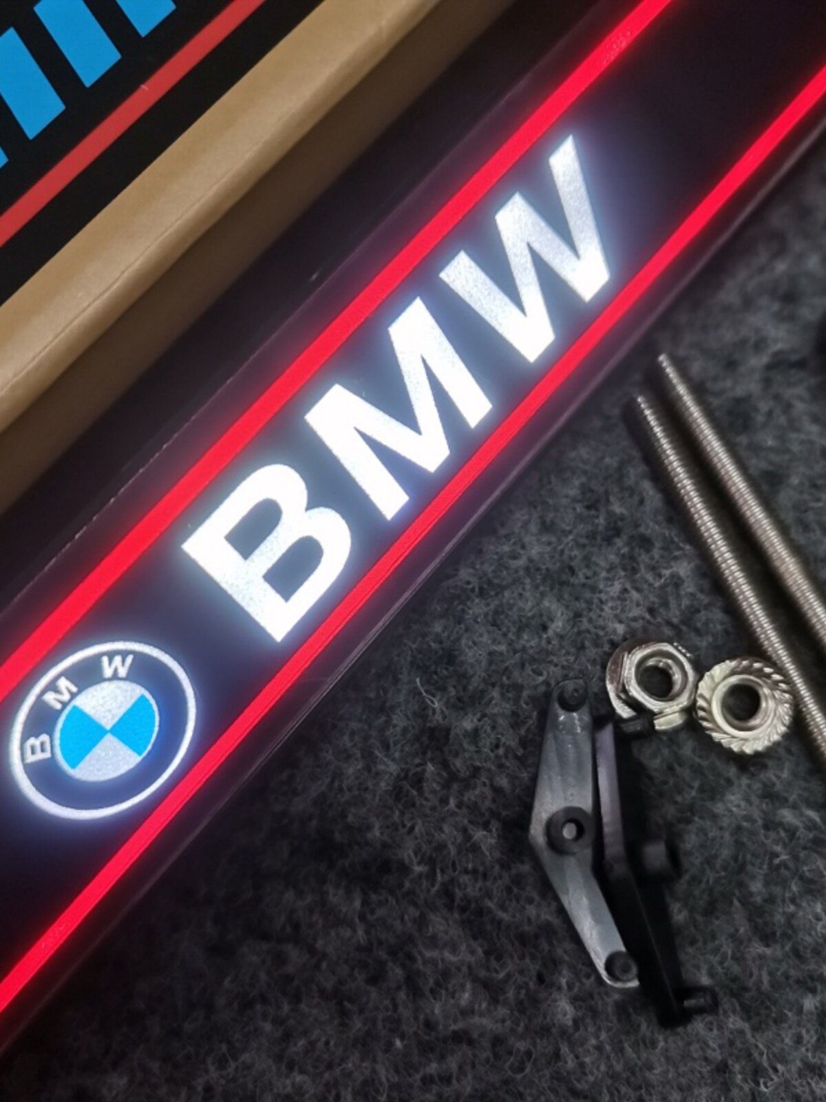 Close up of illuminated BMW LED grille badge with red outline glow