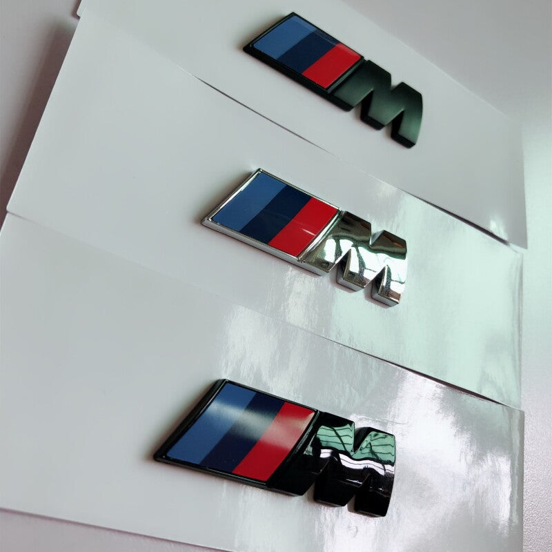 BMW M side badge close-up in Silver, Glossy Black and Matte Black
