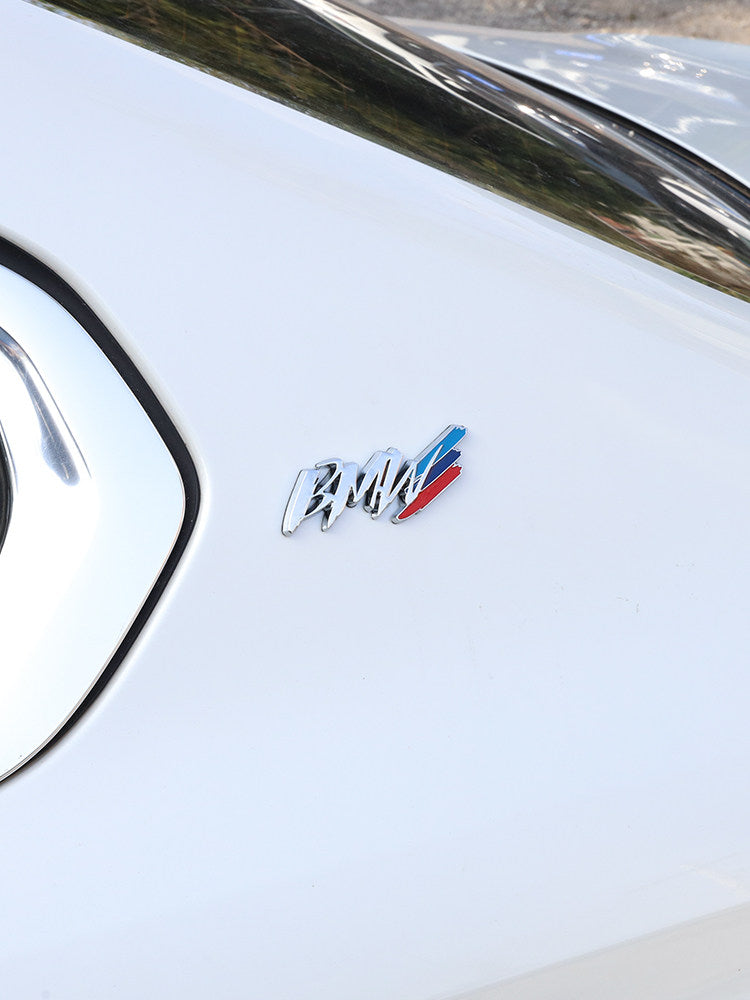 BMW metal badge installed on white car front fender