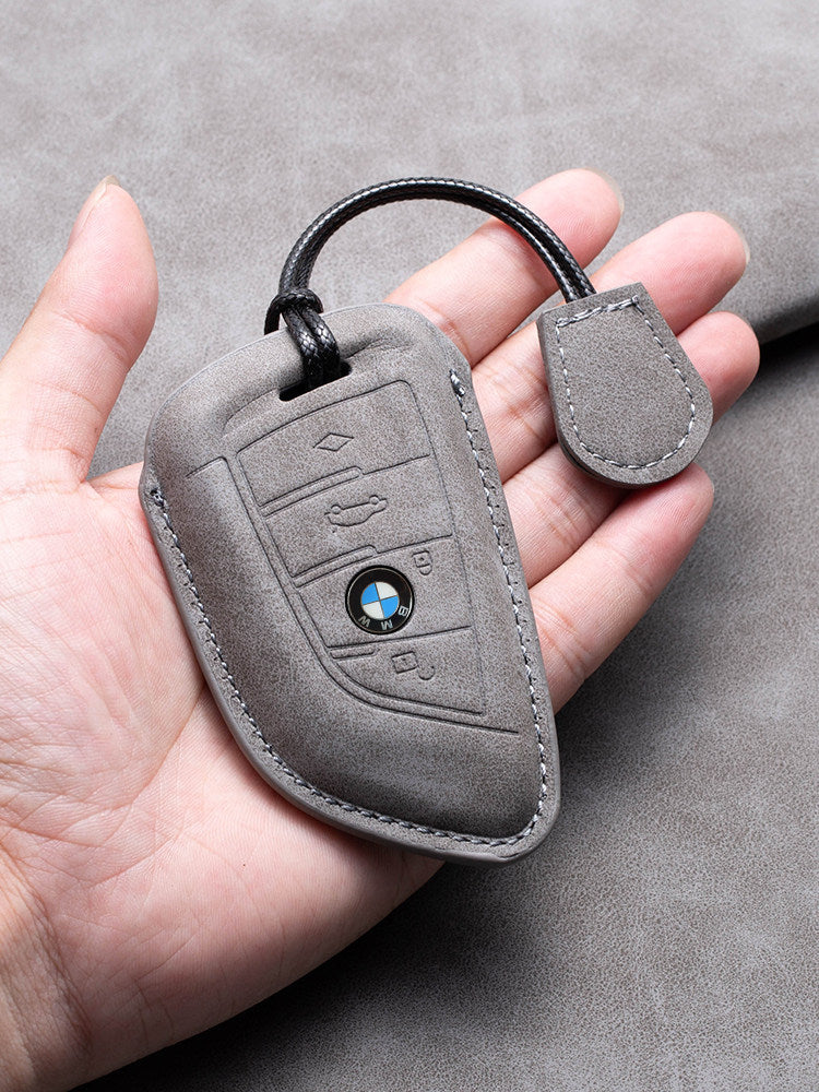 BMW leather key case held in hand, gray suede with keychain