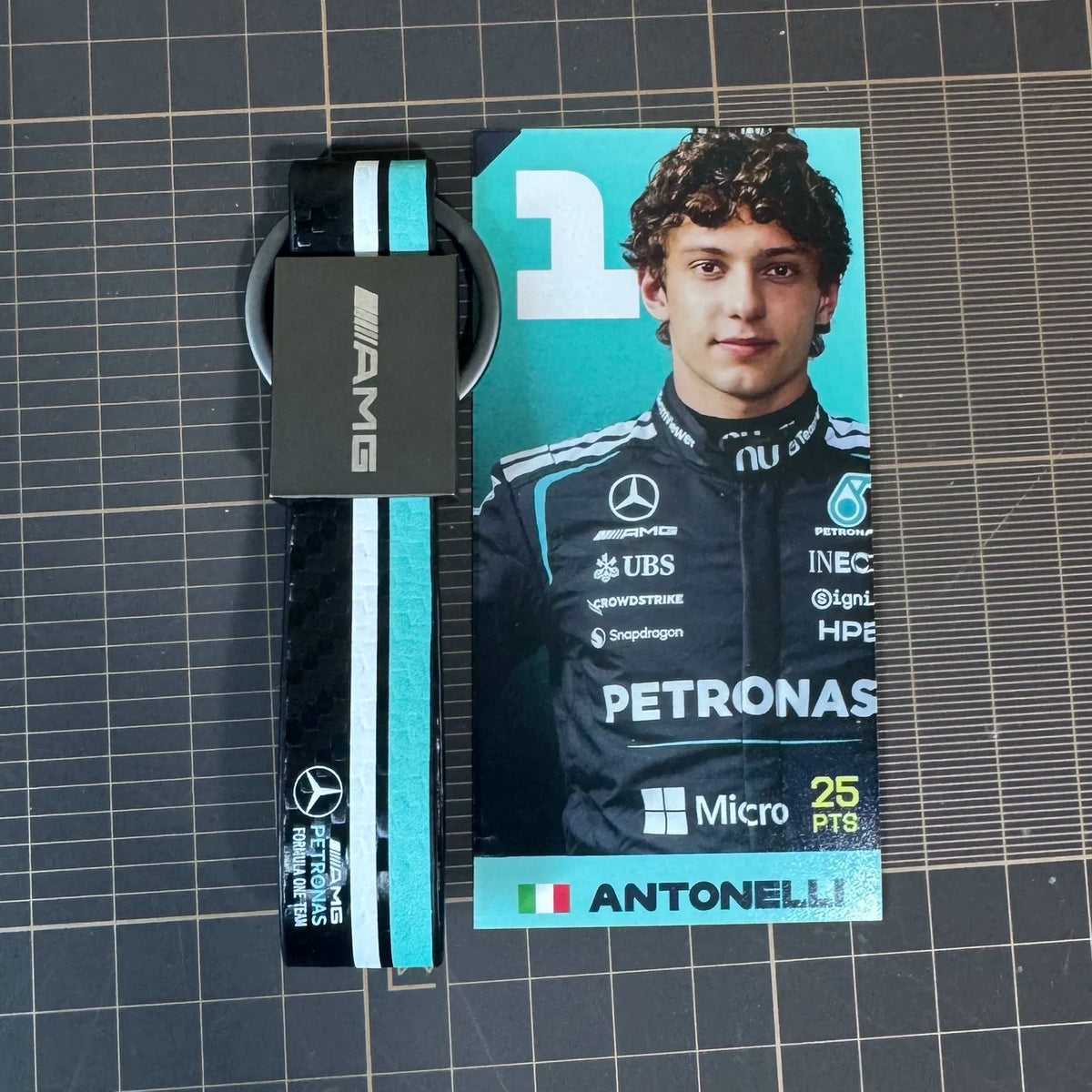 AMG strap keychain with carbon look, white and teal racing stripes
