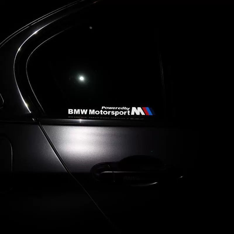 BMW M window decal glowing under night lighting on car door window