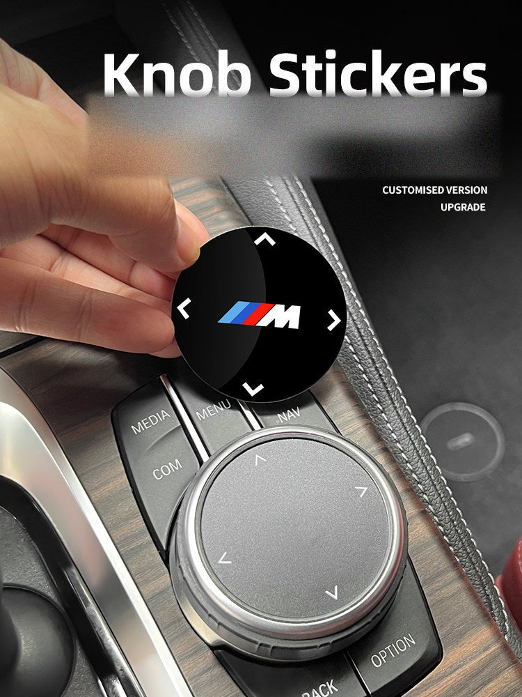 Customized BMW M multimedia knob sticker being applied by hand
