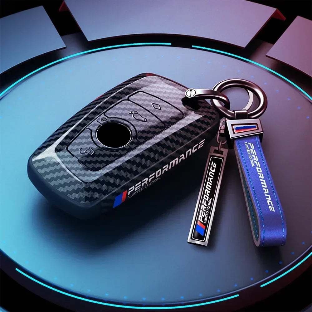 BMW carbon fiber key cover with keychain, angled studio shot