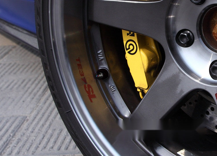 BMW M valve cap installed on a car wheel with brake caliper