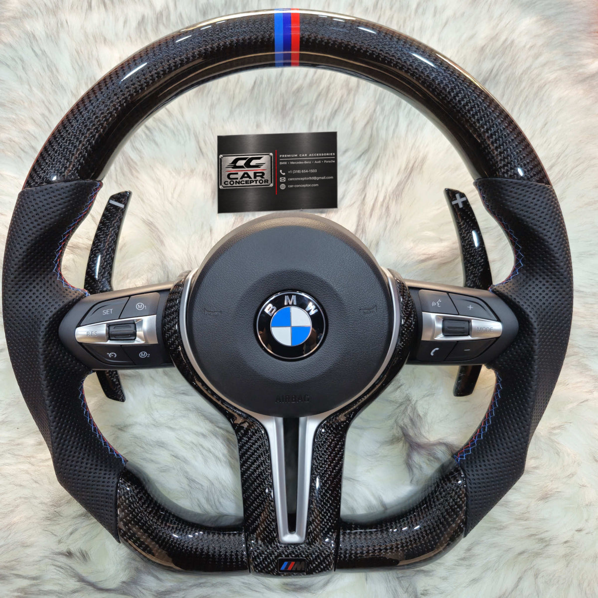 Carbon fiber BMW F Series M steering wheel with silver trim and M colour stripe, with Car Conceptor business card