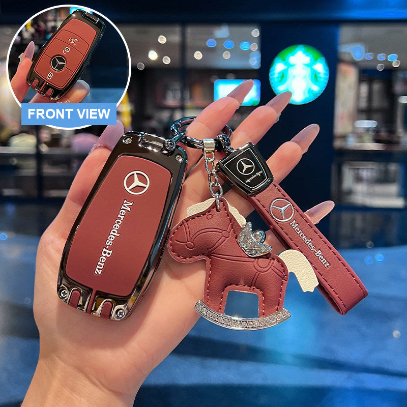 Mercedes-Benz key case in red held in hand with rocking horse charm