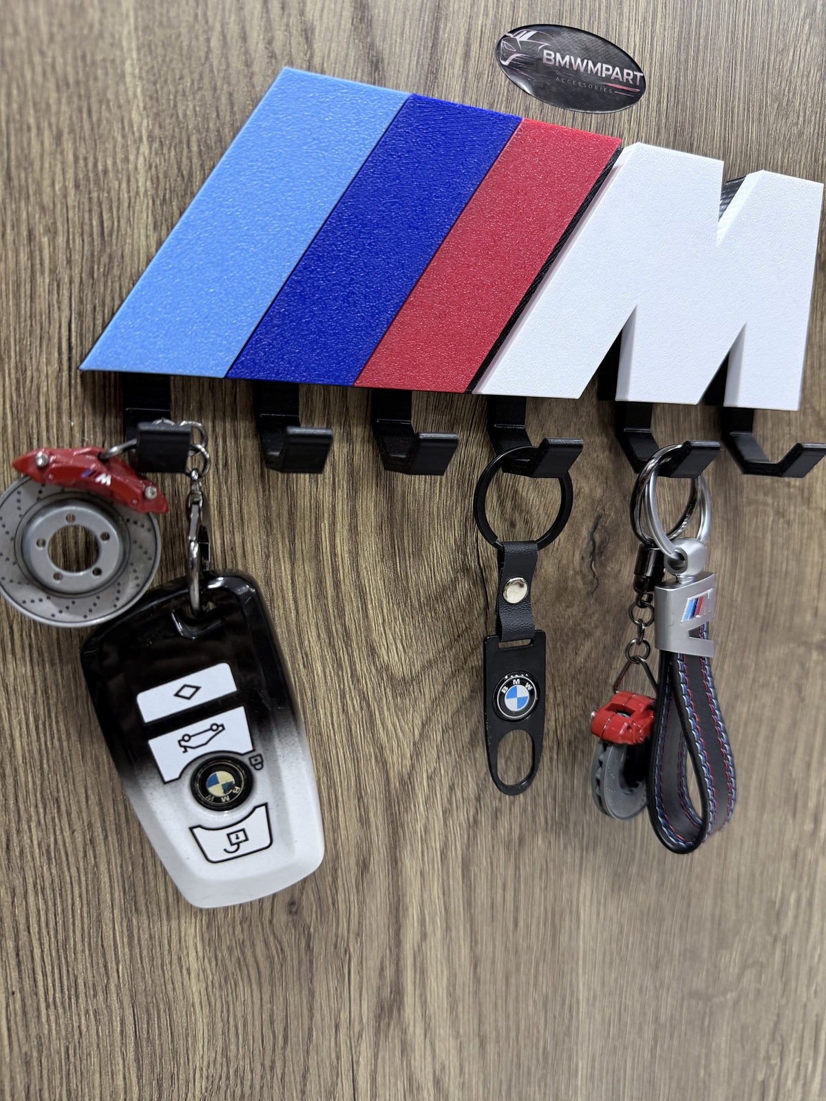 Close-up of BMW M color key rack with BMW leather keychain and brake caliper keychain