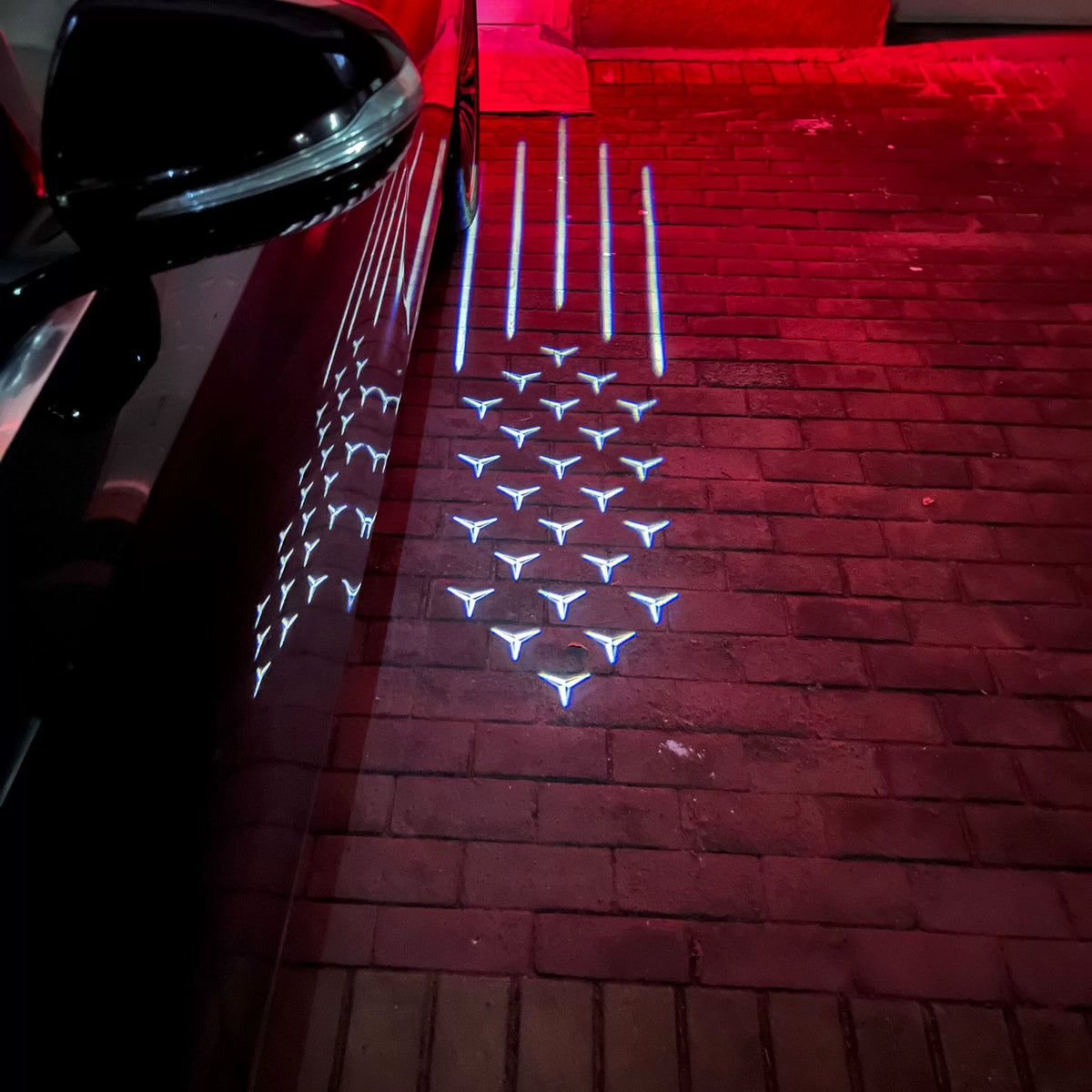 Mercedes-Benz shooting star mirror puddle light on a brick driveway at night