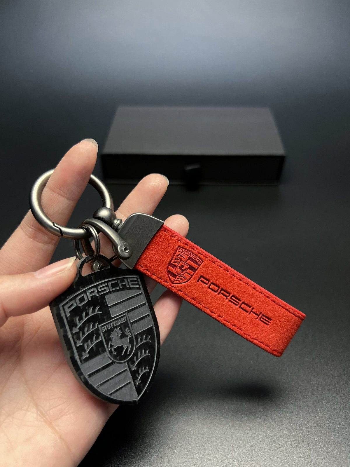 Porsche carbon fiber crest keychain with red suede strap