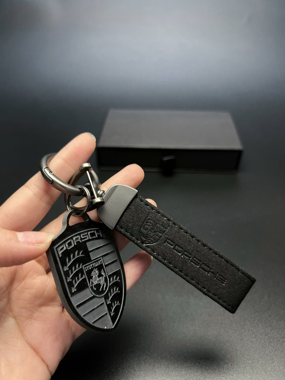 Porsche carbon fiber crest keychain with black suede strap
