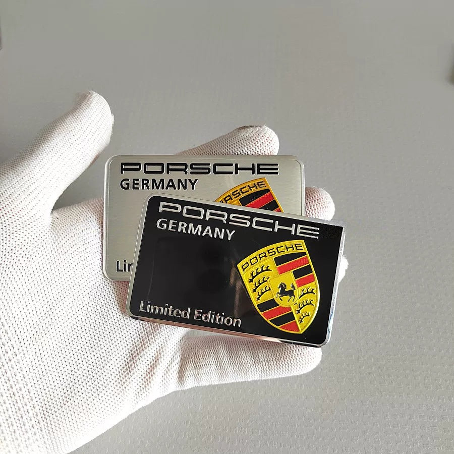 Porsche Germany Limited Edition crest badge in silver and black, held in hand